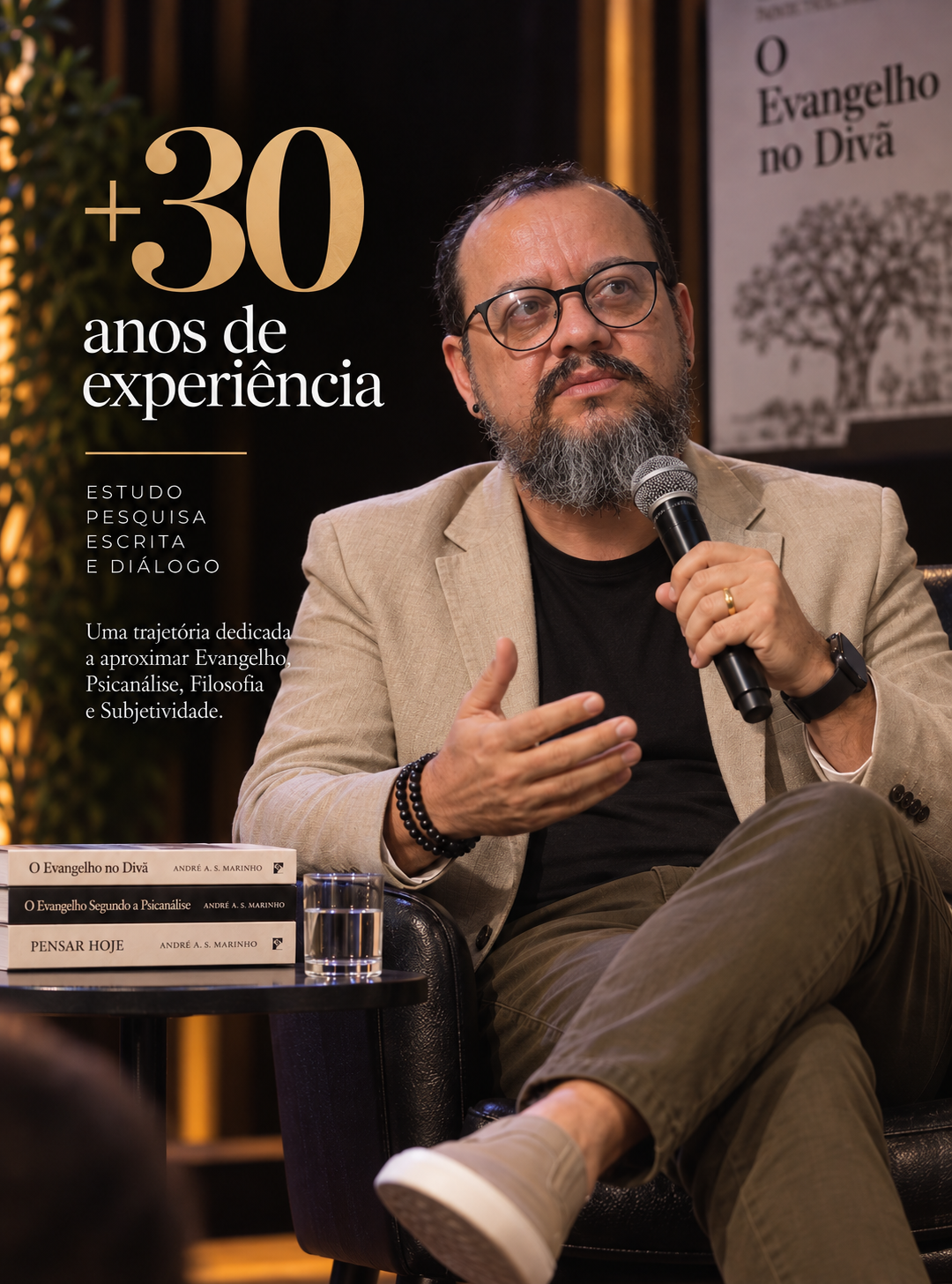André AS Marinho em entrevista, ao lado dos livros do projeto O Evangelho no Divã